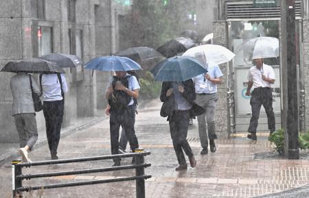 　大雨の中、傘を差して歩く人たち＝１１日午後３時３４分、東京都中央区