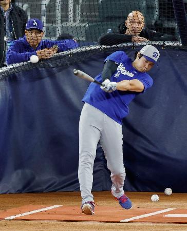 グラウンドで打撃練習するドジャース・大谷。左はロバーツ監督=トロント(共同)