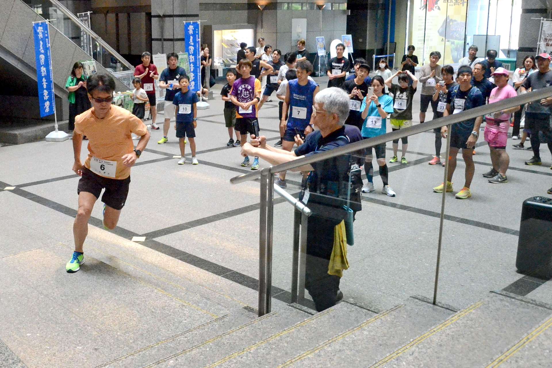 １階から最上階目指して駆け上がる参加者＝県庁