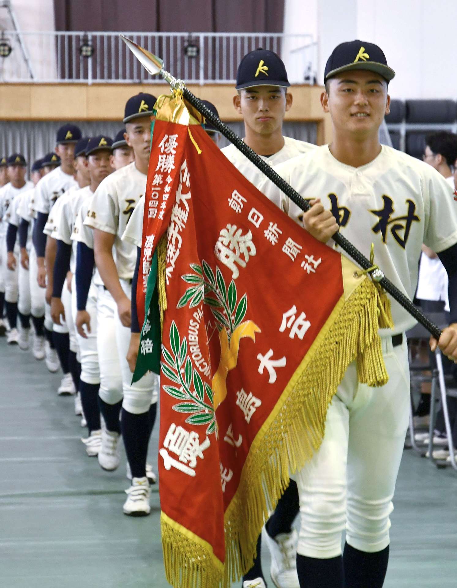 夏の県大会優勝旗を手に入場する神村学園ナイン＝いちき串木野市の同学園