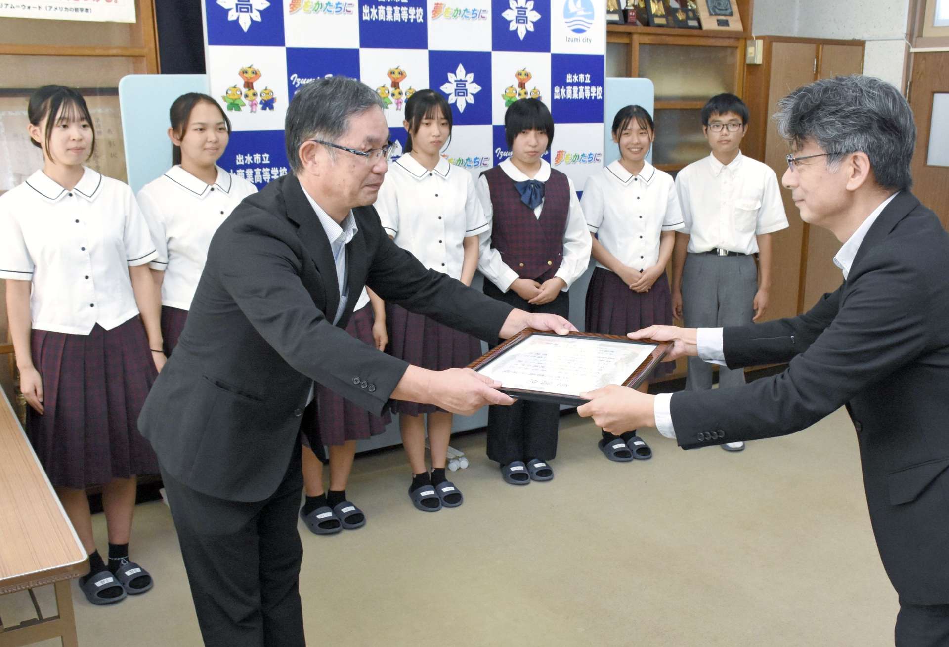 中村誠希社長（右）から感謝状を受け取る竹之下純與校長＝出水市の出水商業高校