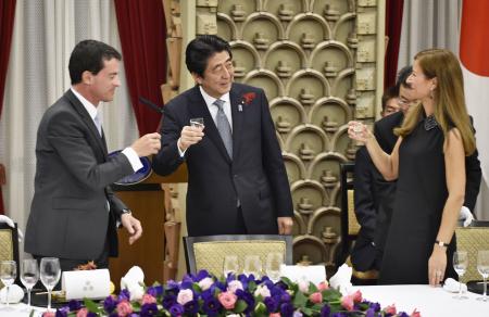 　フランスのバルス首相（左）を招いて開かれた夕食会で乾杯する安倍首相（中央）＝５日夜、首相公邸