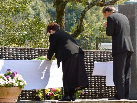 　私立高知学芸高で営まれた上海列車事故の慰霊式で献花する遺族ら＝２４日午前、高知市