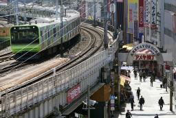 　外出自粛要請で閑散とするアメ横商店街と、横を走るＪＲ山手線＝４日、東京・上野