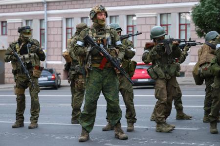 24日、ロシア南部ロストフ州の州都ロストフナドヌーにある南部軍管区司令部の外に展開する民間軍事会社ワグネルの戦闘員ら(タス=共同)