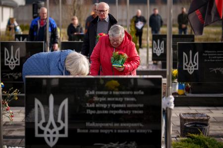 3月31日、ウクライナ・ブチャでロシア占領下に犠牲となった人々を追悼する式典が開かれ、戦死したウクライナ兵の墓に花を供える親族(AP=共同)