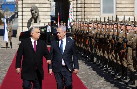 　３日、ハンガリー・ブダペストでの歓迎式典で並んで歩くオルバン首相（左）とイスラエルのネタニヤフ首相（ロイター＝共同）