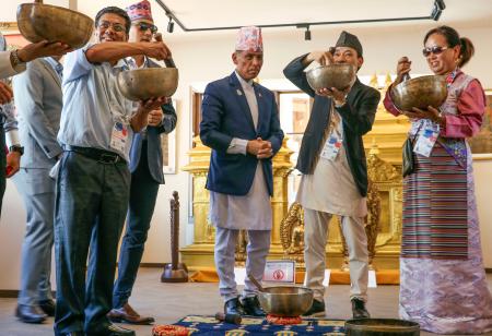 　ネパール館がオープンし、「シンギングボウル」を演奏する人たち。中央はドゥルガ・バハドゥール・スベディ駐日大使＝１９日午後、大阪市此花区の夢洲