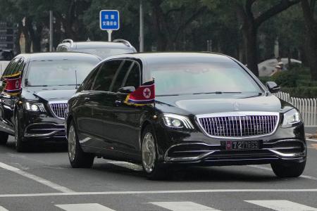　北朝鮮の国旗を掲げ、北京市内を走る車列＝２日（共同）