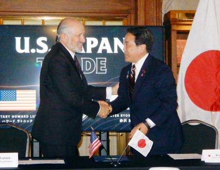　日米関税合意に関する文書に署名し、握手する赤沢経済再生相（右）とラトニック米商務長官＝４日、ワシントン（共同）