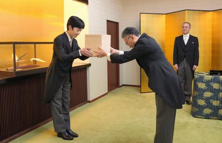 　「冠を賜うの儀」で、天皇陛下の使者から成年用の冠を受け取られる秋篠宮家の長男悠仁さま＝６日午前８時４５分、東京・元赤坂の秋篠宮邸（宮内庁提供）