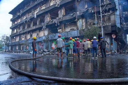 　１０日、ネパールの首都カトマンズで、襲撃されたショッピングセンターで消火活動をする人々（ＡＰ＝共同）