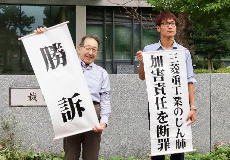 　控訴審判決を受け、「勝訴」などと書かれた紙を掲げる原告側弁護士ら＝１１日午後、福岡高裁前