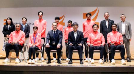 陸上の世界選手権東京大会に出場した日本代表選手らと記念写真に納まる、スポーツ庁の室伏広治長官(前列中央左)=26日、東京都千代田区