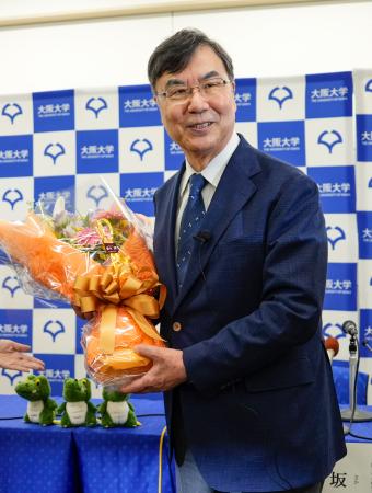 　ノーベル生理学・医学賞の受賞が決まり、記者会見場で花束を手に笑顔を見せる大阪大の坂口志文特任教授＝６日午後８時３分、大阪府吹田市