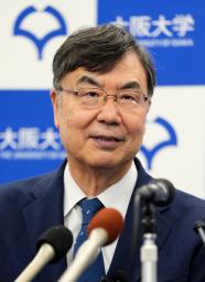 　ノーベル生理学・医学賞の受賞が決まり、記者会見場で花束を手に笑顔を見せる大阪大の坂口志文特任教授＝６日午後８時３分、大阪府吹田市