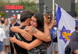　９日、イスラエル中部テルアビブで喜ぶ、息子がハマスに拘束されたダニ・ミランさん（左）（共同）
