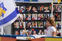 　ガザ南部ハンユニスで荷物を持って歩く人たち。イスラエルとイスラム組織ハマスの停戦が発効した＝１０日（ＡＰ＝共同）
