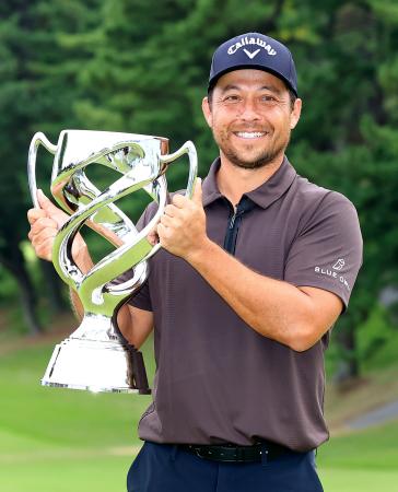 　通算１９アンダーで優勝し、トロフィーを手に笑顔のザンダー・シャウフェレ＝横浜ＣＣ