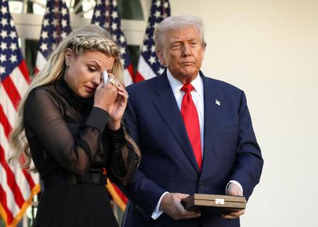 　米ホワイトハウスで、保守系活動家チャーリー・カーク氏の妻エリカさん（左）と並ぶトランプ大統領＝１４日、ワシントン（ロイター＝共同）