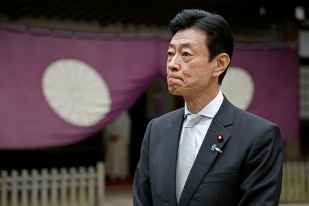 　靖国神社を参拝し、記者団の取材に応じる西村元経産相＝１８日午前、東京・九段北