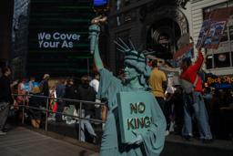 　１８日、自由の女神像に扮し米ニューヨークで「ＮＯ　ＫＩＮＧＳ（王はいらない）」に参加した人（ＡＰ＝共同）