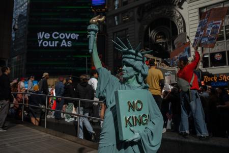 　１８日、自由の女神像に扮し米ニューヨークで「ＮＯ　ＫＩＮＧＳ（王はいらない）」に参加した人（ＡＰ＝共同）