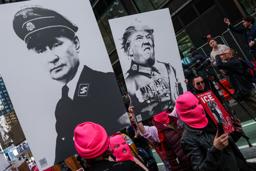 　ナチスの制服姿で描いたトランプ米大統領（右）とロシアのプーチン大統領のプラカードを掲げ、「ＮＯ　ＫＩＮＧＳ（王はいらない）」デモに参加した人たち＝米ニューヨーク（ロイター＝共同）