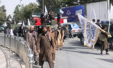 　８月、アフガニスタンの首都カブールで、タリバンの旗を掲げて復権４年を誇示する治安部隊員や支持者ら（共同）