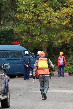 　ヒグマ２頭が居座った公園に向かうハンター＝２３日午前、札幌市西区
