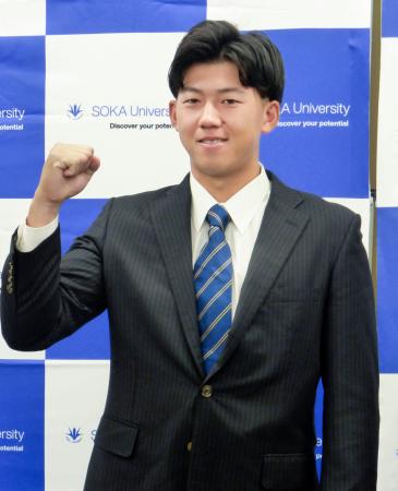 　阪神からの指名あいさつを受け、ガッツポーズする創価大の立石正広内野手＝２４日、東京都八王子市