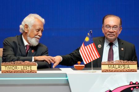 　２６日、東ティモールのグスマン首相（左）にあいさつするマレーシアのアンワル首相＝クアラルンプール（ＡＰ＝共同）