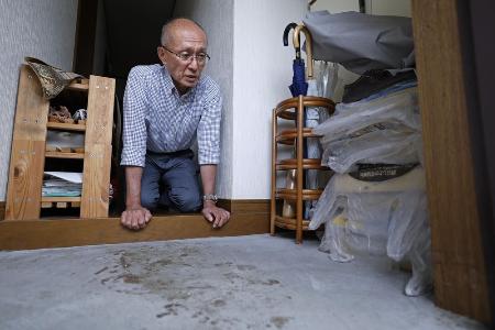 高羽奈美子さんが殺害されたアパートの玄関に残る犯人のものとみられる血痕を見つめ、取材に応じる夫悟さん=昨年11月、名古屋市