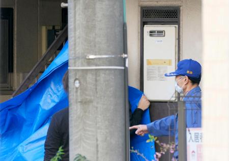 　事件があったアパートを現場検証するため、シートを張る愛知県警の捜査員＝１日午後、名古屋市西区