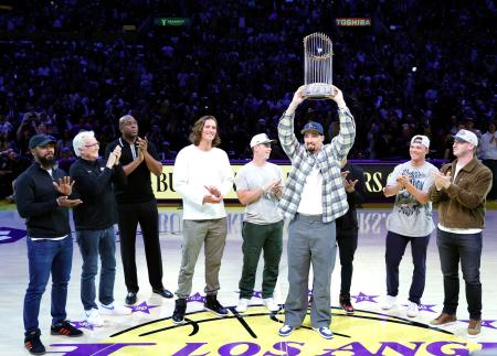 　レーカーズ戦のコートに登場し、優勝トロフィーを掲げるドジャースのスネル＝５日、ロサンゼルス（ゲッティ＝共同）