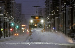　今季初めて出動し、軌道に積もった雪を掃き飛ばす「ササラ電車」＝８日午前６時３分、札幌市中央区