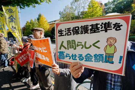 　専門委員会を前に生活保護費の全額補償を訴える人たち＝１７日午前、東京・霞が関の厚労省前