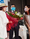 当選を確実にし、花束を受け取る塩田康一氏＝１２日午後１０時５６分、鹿児島市荒田１丁目