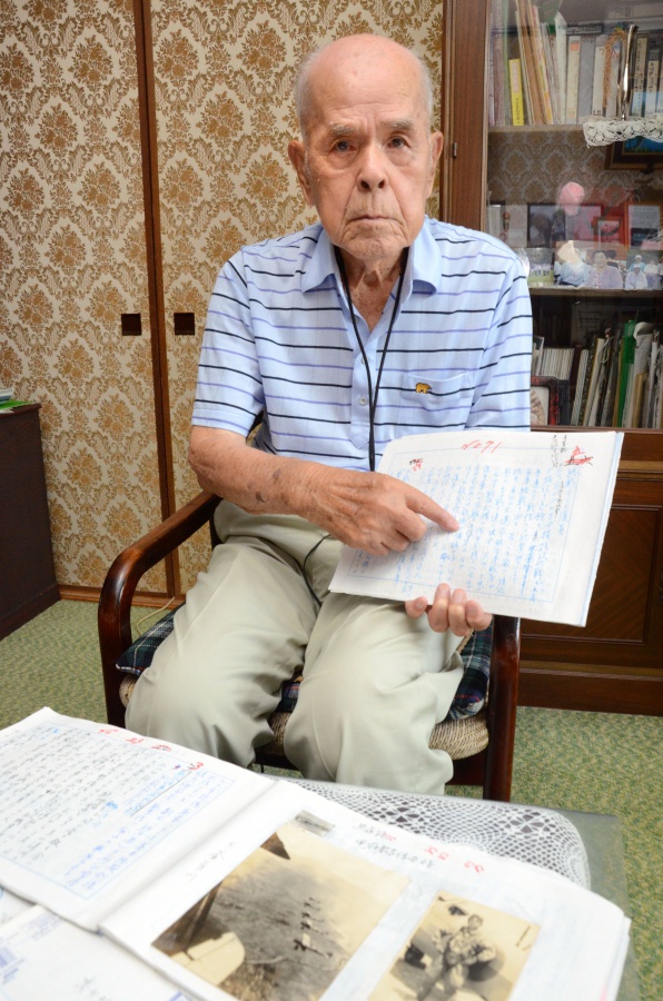 記憶をつづった手記を手に、特攻隊員当時の葛藤と苦悩を語る東郷勝次さん＝都城市鷹尾３丁目