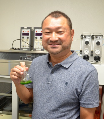 ミドリムシの入ったビーカーを持つ林雅弘教授＝宮崎市の宮崎大学