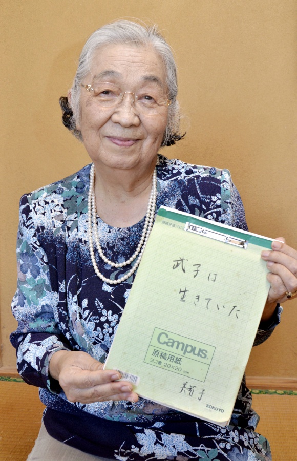 妹との再会の経緯をつづった手記を手にする花田美智子さん＝鹿児島市郡山町
