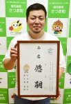 人気テレビアニメ「鬼滅の刃」で使われた「闘龍」の書体で書かれた命名書を持つ大園良平さん＝さつま町役場