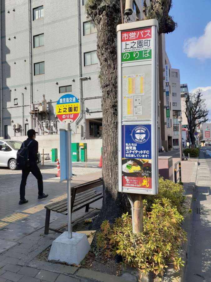 上之園町のバス停。高さ約１９０センチの位置に時刻表がある。歩道の傾斜もあり、かなり見にくい＝鹿児島市上之園町