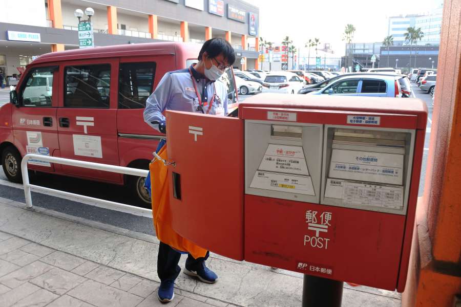 ポストから郵便物を収集する職員＝鹿児島市与次郎１丁目