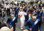 手を振り笑顔で走る聖火ランナーの上白石萌歌さん＝２８日午後５時、南九州市知覧町郡