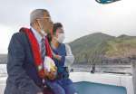 江名武彦さんが不時着した海を見つめる日高康雄さん（写真左）と小林ちえみさん（同右）＝１１日、三島村黒島の赤鼻沖