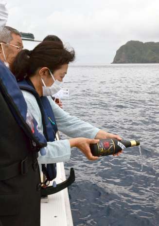 お神酒をまく小林さん＝三島村黒島の赤鼻沖