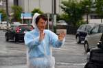 行き交う車に手を振る三反園訓氏