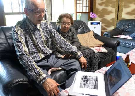 カラー化された写真を見て鹿児島大空襲の夜を思い出す吉峯幸一さん、睦子さん夫妻＝１０日、南さつま市加世田唐仁原