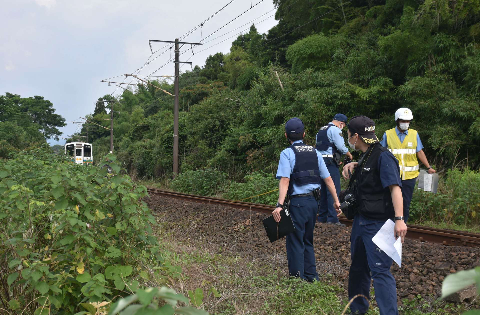 事故現場付近を調べる捜査員ら＝20日午後4時40分ごろ、出水市野田町下名